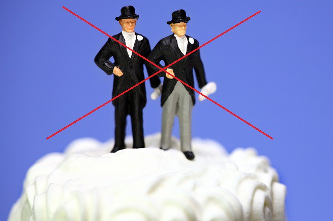 Miniature homosexual couple on a wedding cake. Gay marriage.